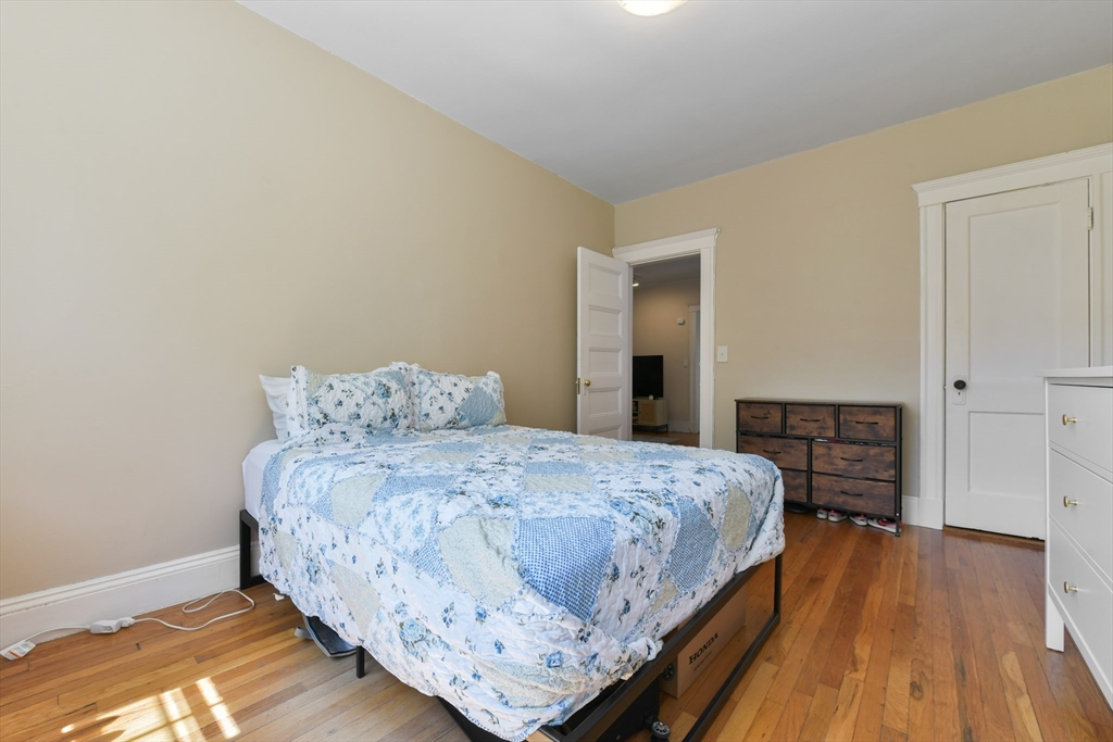 301 Allston Street, Unit 7 Boston, MA 02135 - Photo 18 of 25 a bedroom with a bed and wooden floor