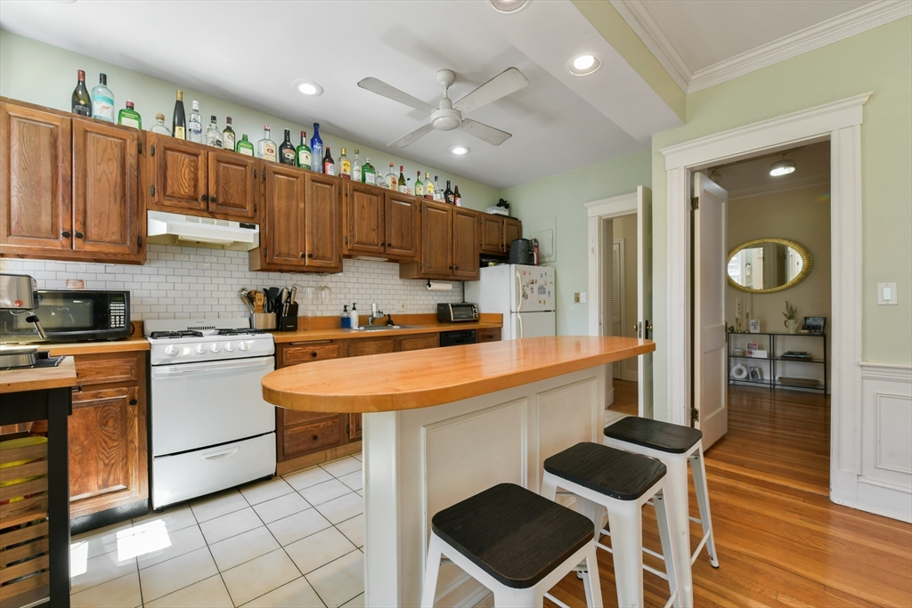 301 Allston Street, Unit 7 Boston, MA 02135 - Photo 9 of 25 a kitchen with stainless steel appliances kitchen island granite countertop a sink and cabinets