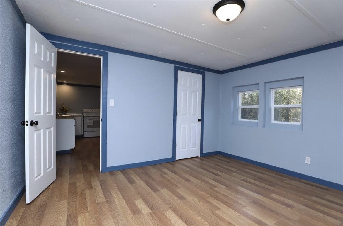 22965 Highway 146 Cleveland, TX 77327 - Photo 11 of 18 an empty room with wooden floor and windows