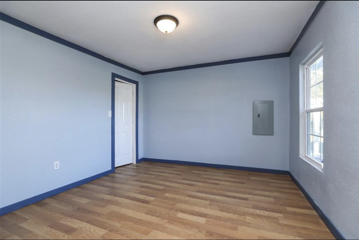 22965 Highway 146 Cleveland, TX 77327 - Photo 12 of 18 an empty room with wooden floor and windows