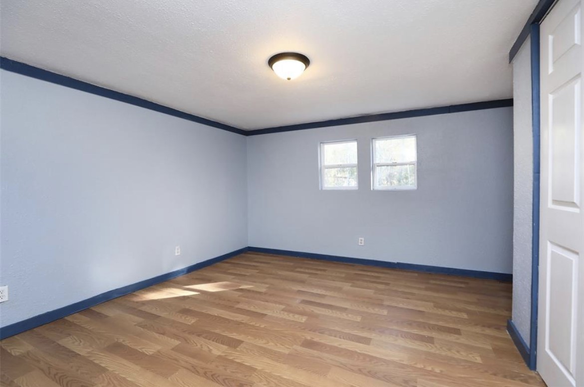 22965 Highway 146 Cleveland, TX 77327 - Photo 13 of 18 an empty room with wooden floor and windows