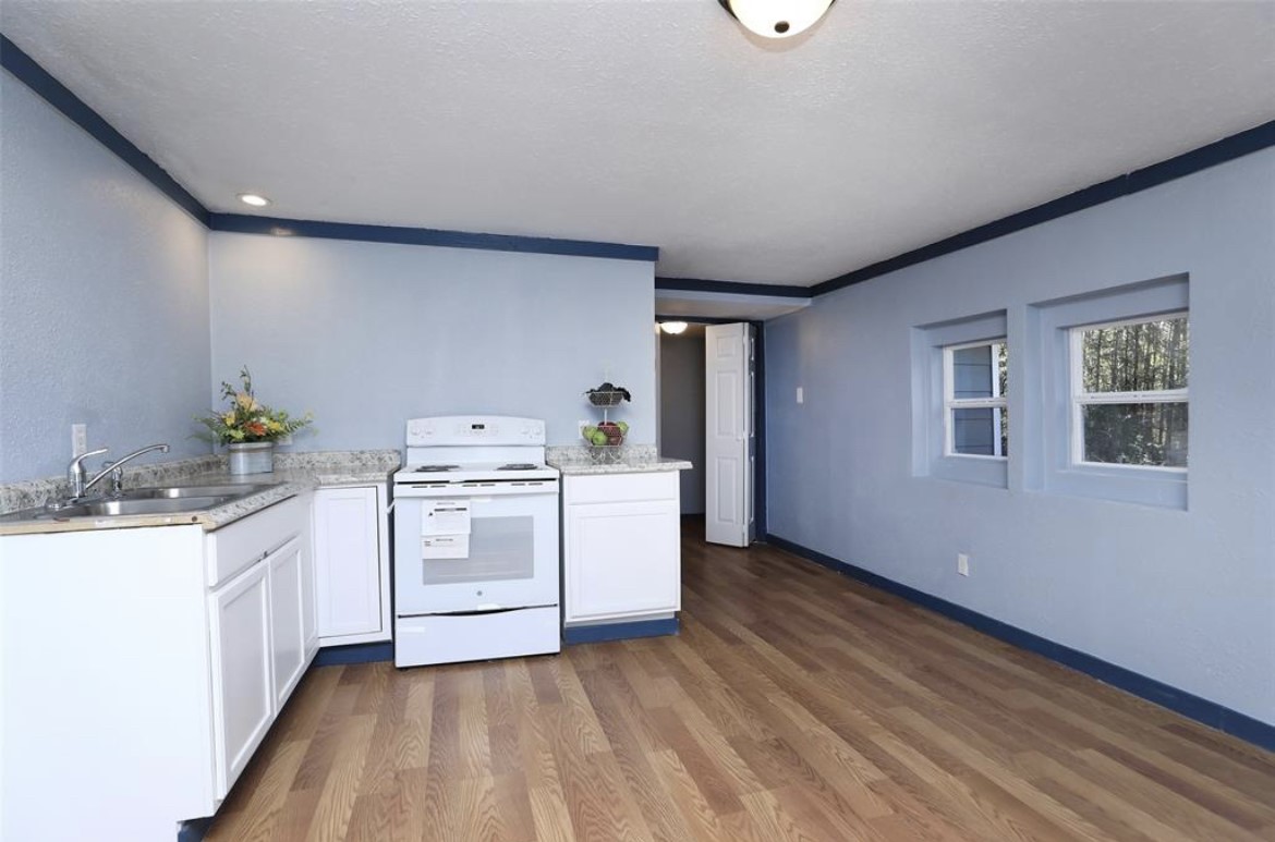 22965 Highway 146 Cleveland, TX 77327 - Photo 8 of 18 a kitchen with sink cabinets and stove top oven
