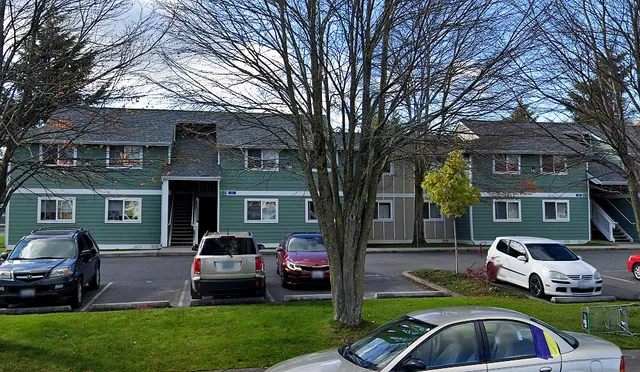 a front view of a house with a garden and trees