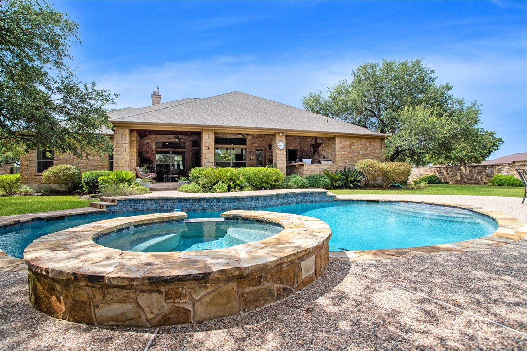 a view of house with swimming pool and yard