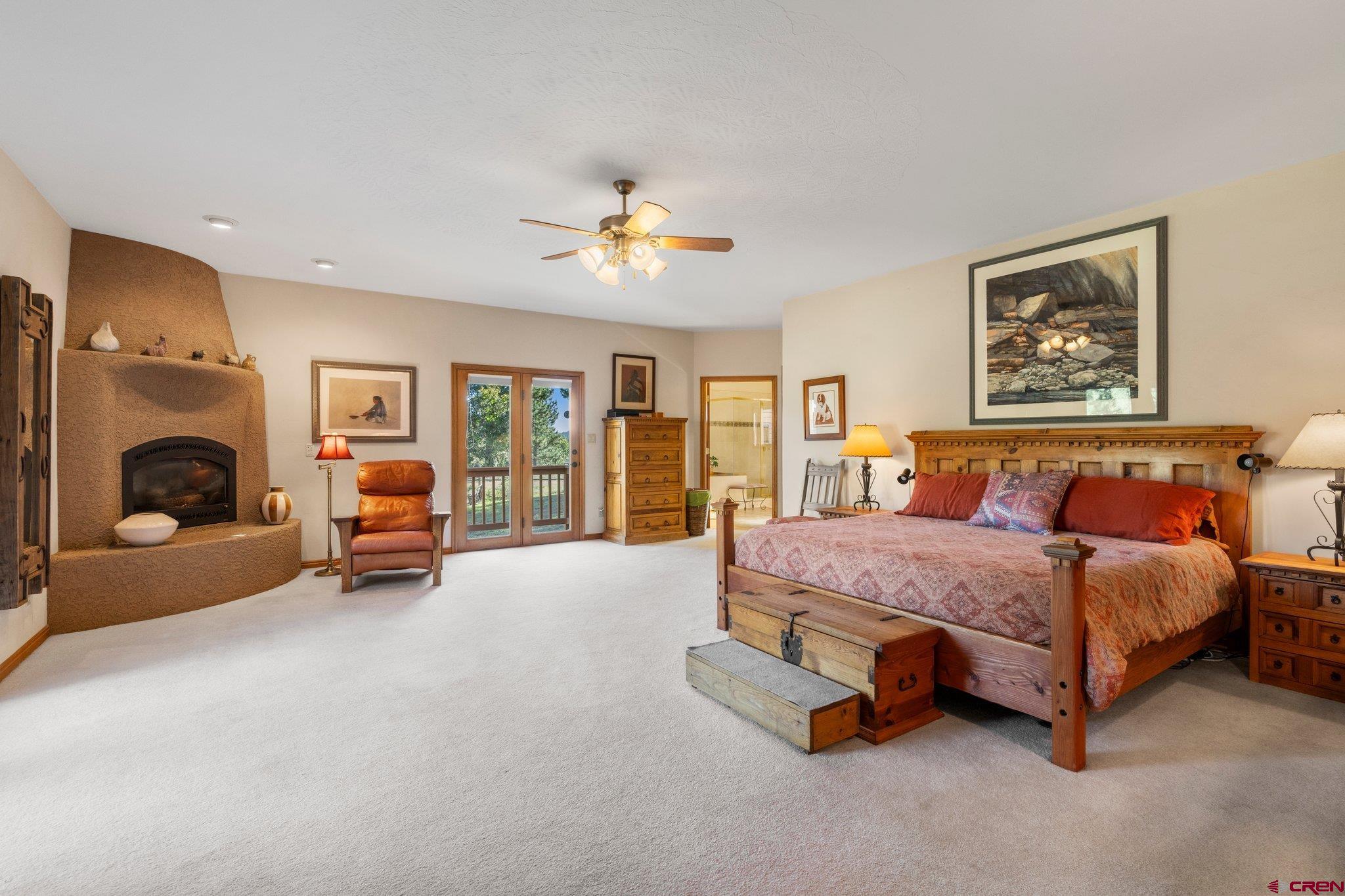 747 Oak Drive Durango, CO 81301 - Photo 11 of 34 a spacious bedroom with a bed couch and a chandelier