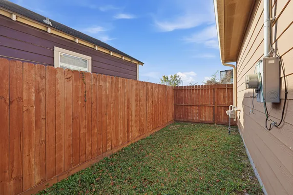 a view of a backyard with wooden fence
