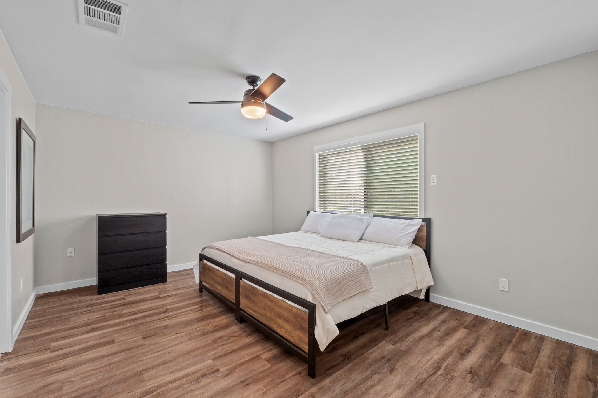 11811 Rotherham Drive Austin, TX 78754 - Photo 18 of 37 A well-lit bedroom features durable laminate flooring and a ceiling fan for comfort.