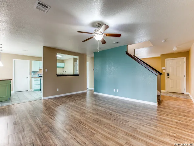 a view of an empty room with window and wooden floor