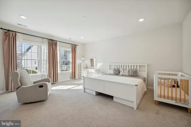 a spacious bedroom with a bed and a couch with window