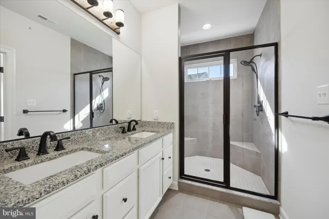 a bathroom with a granite countertop sink mirror and shower