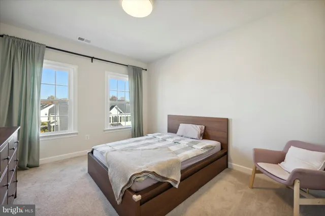 a large bed sitting in a bedroom next to a window