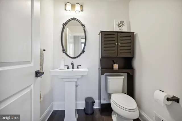 a bathroom with a toilet a sink and mirror
