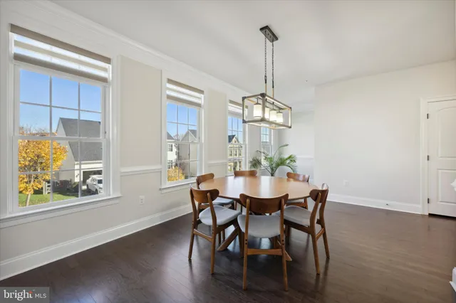 a view of a dining room with furniture a chandelier and wooden floor