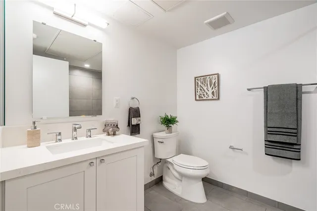 a bathroom with a white bath tub a toilet a sink and mirror