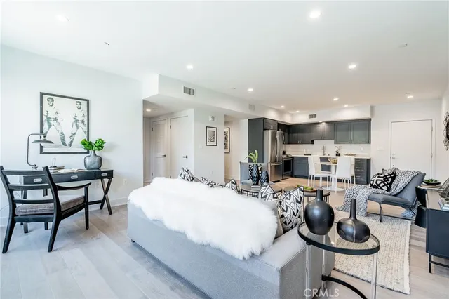 a living room with furniture kitchen view and a flat screen tv