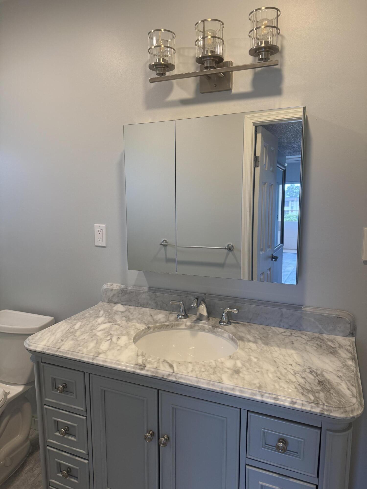 4 Greenway Village North, Unit 203 Royal Palm Beach, FL 33411 - Photo 11 of 19 a bathroom with a sink and a mirror