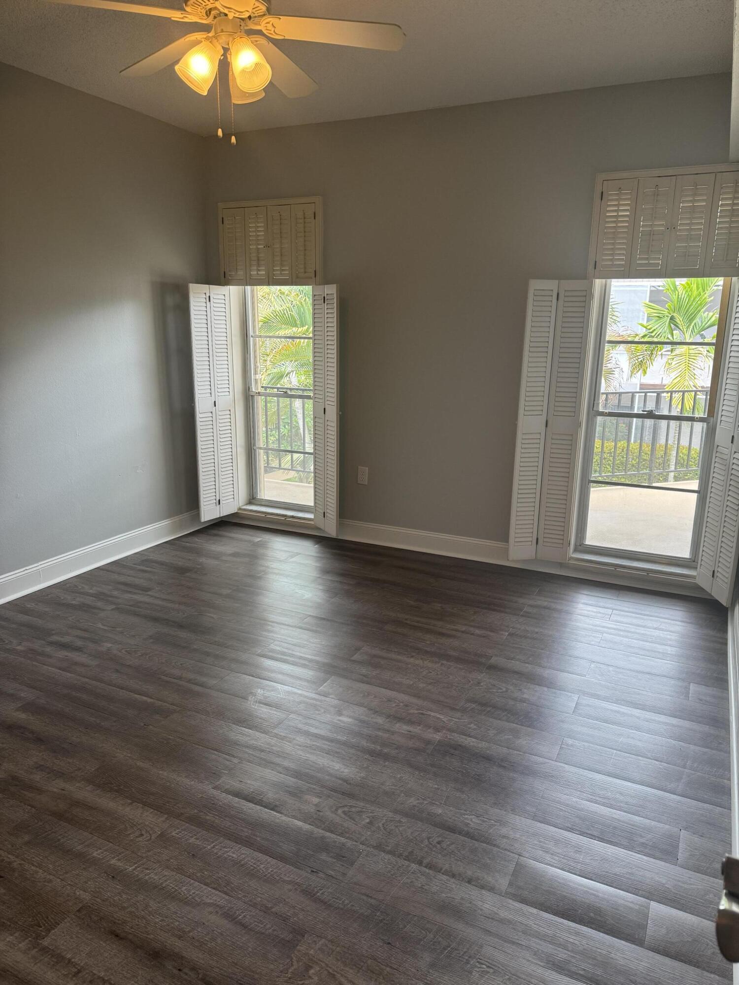 4 Greenway Village North, Unit 203 Royal Palm Beach, FL 33411 - Photo 13 of 19 an empty room with wooden floor and windows