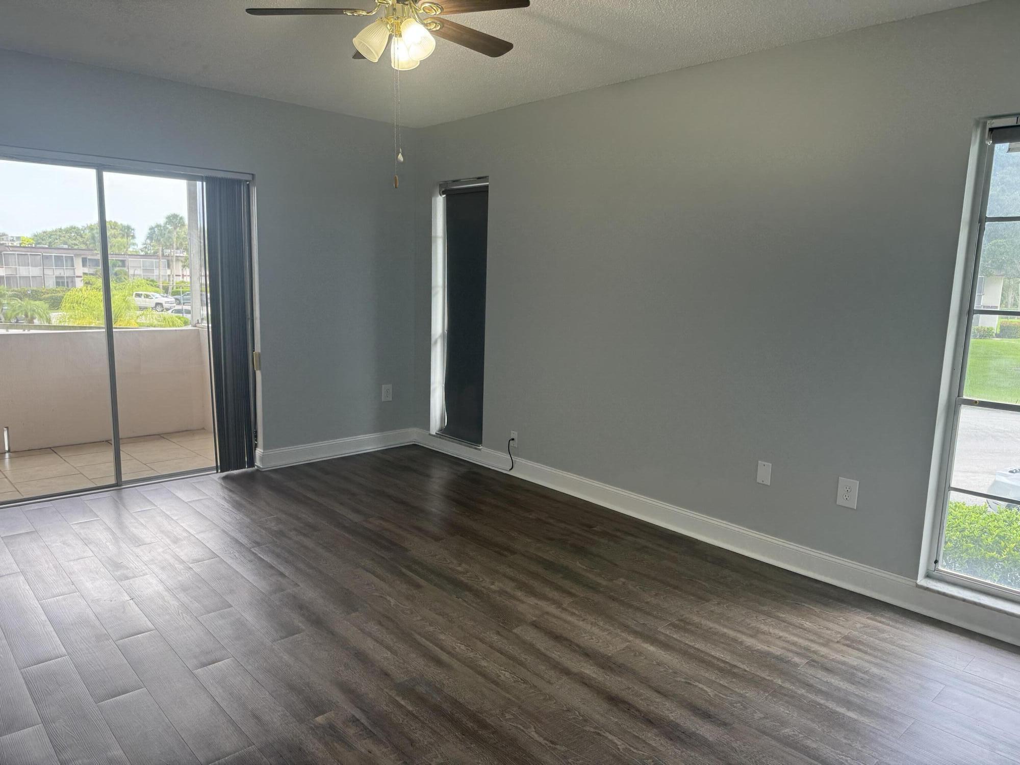 4 Greenway Village North, Unit 203 Royal Palm Beach, FL 33411 - Photo 7 of 19 an empty room with wooden floor and windows