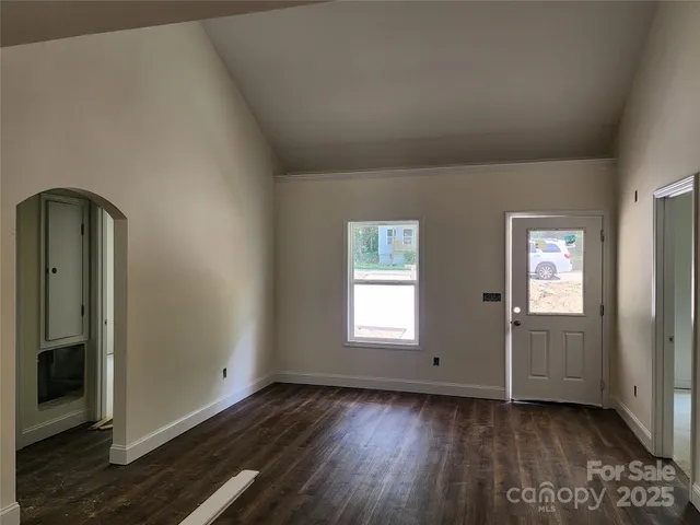 a view of empty room with window and wooden floor