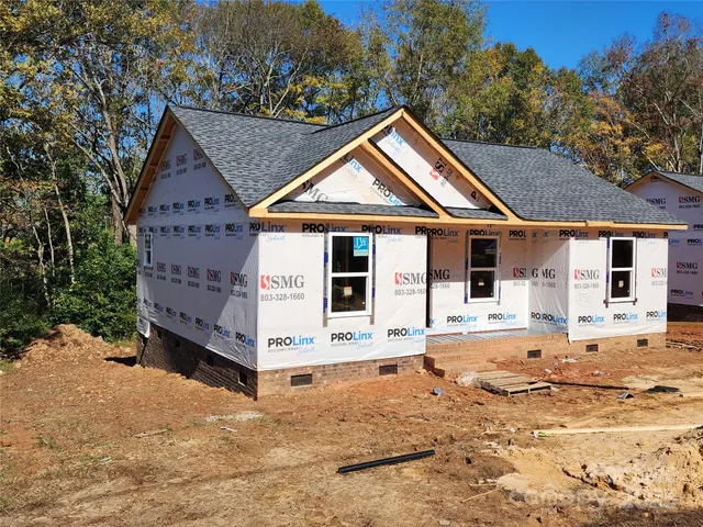 a front view of a house with a yard covered in snow