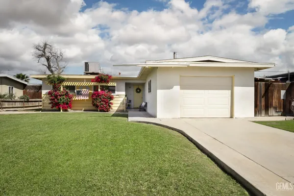 a view of a big house with a big yard and large trees