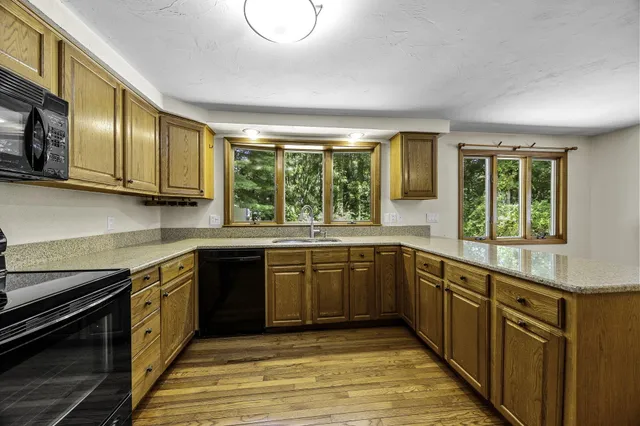a large kitchen with stainless steel appliances granite countertop a stove and a sink