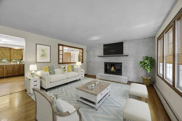 a living room with furniture a flat screen tv and a fireplace