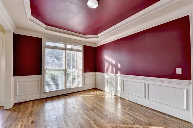 an empty room with wooden floor a fireplace and windows