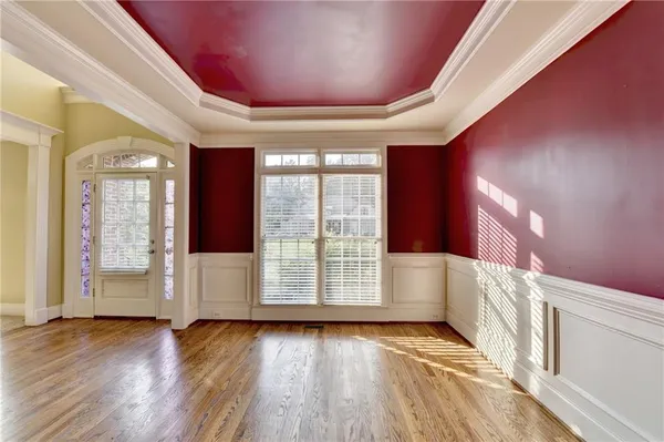 an empty room with windows a fireplace and wooden floor