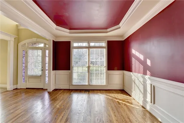 an empty room with windows a fireplace and wooden floor