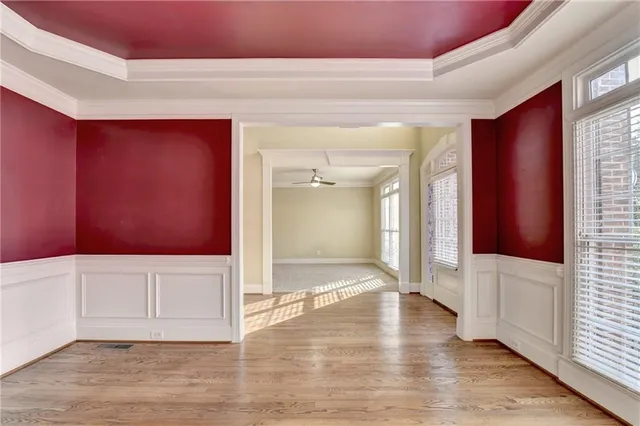 a view of an empty room with wooden floor fireplace and a window