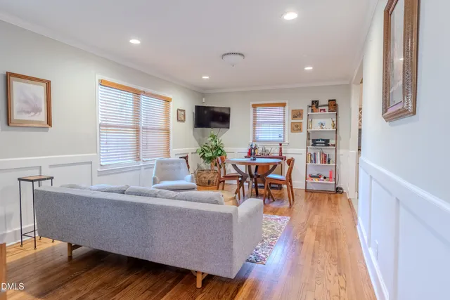 a living room with furniture and a wooden floor