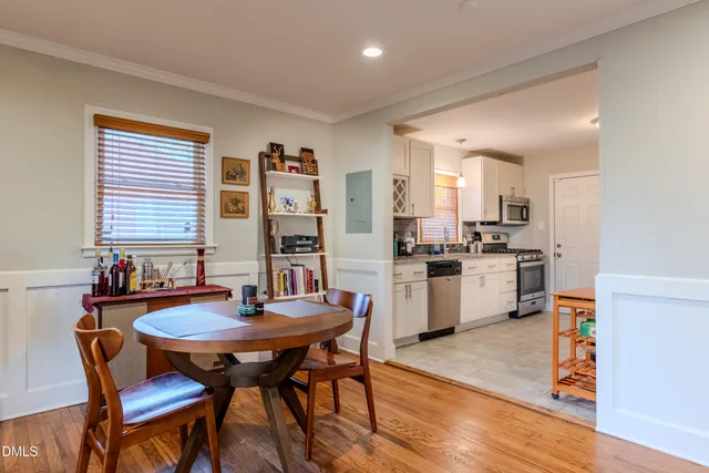 a kitchen with a dining table chairs and refrigerator