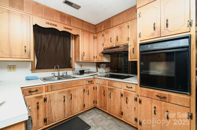 a kitchen with stainless steel appliances granite countertop white cabinets a sink and dishwasher