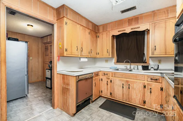 a kitchen with granite countertop a sink stove and cabinets