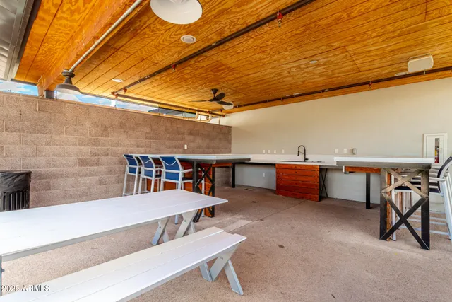 a view of a patio with table and chairs potted plants and a large tree