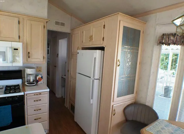 a kitchen with stainless steel appliances a refrigerator and a dresser