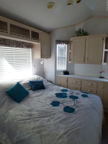 a bed sitting in a bedroom next to a window