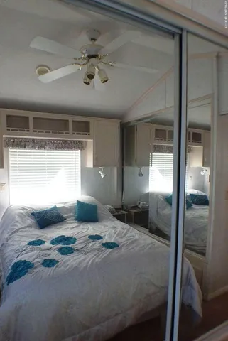 a bedroom with a large bed and windows
