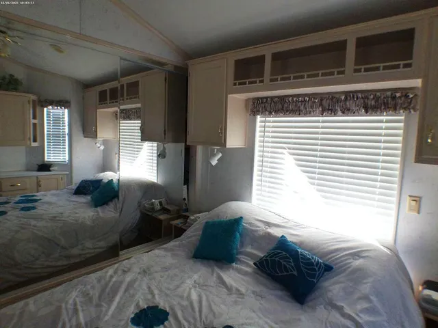 a bedroom with a bed and two windows