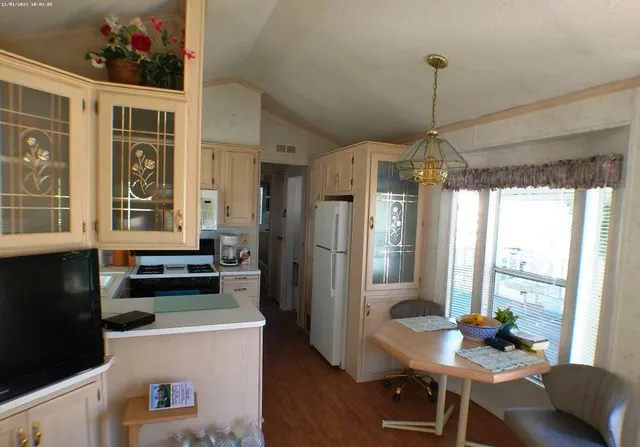 a dining room with furniture a chandelier and wooden floor