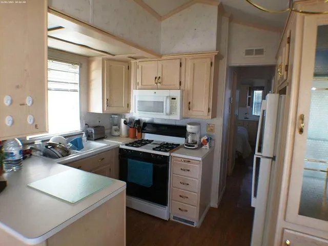 a kitchen that has a sink cabinets counter space and appliances