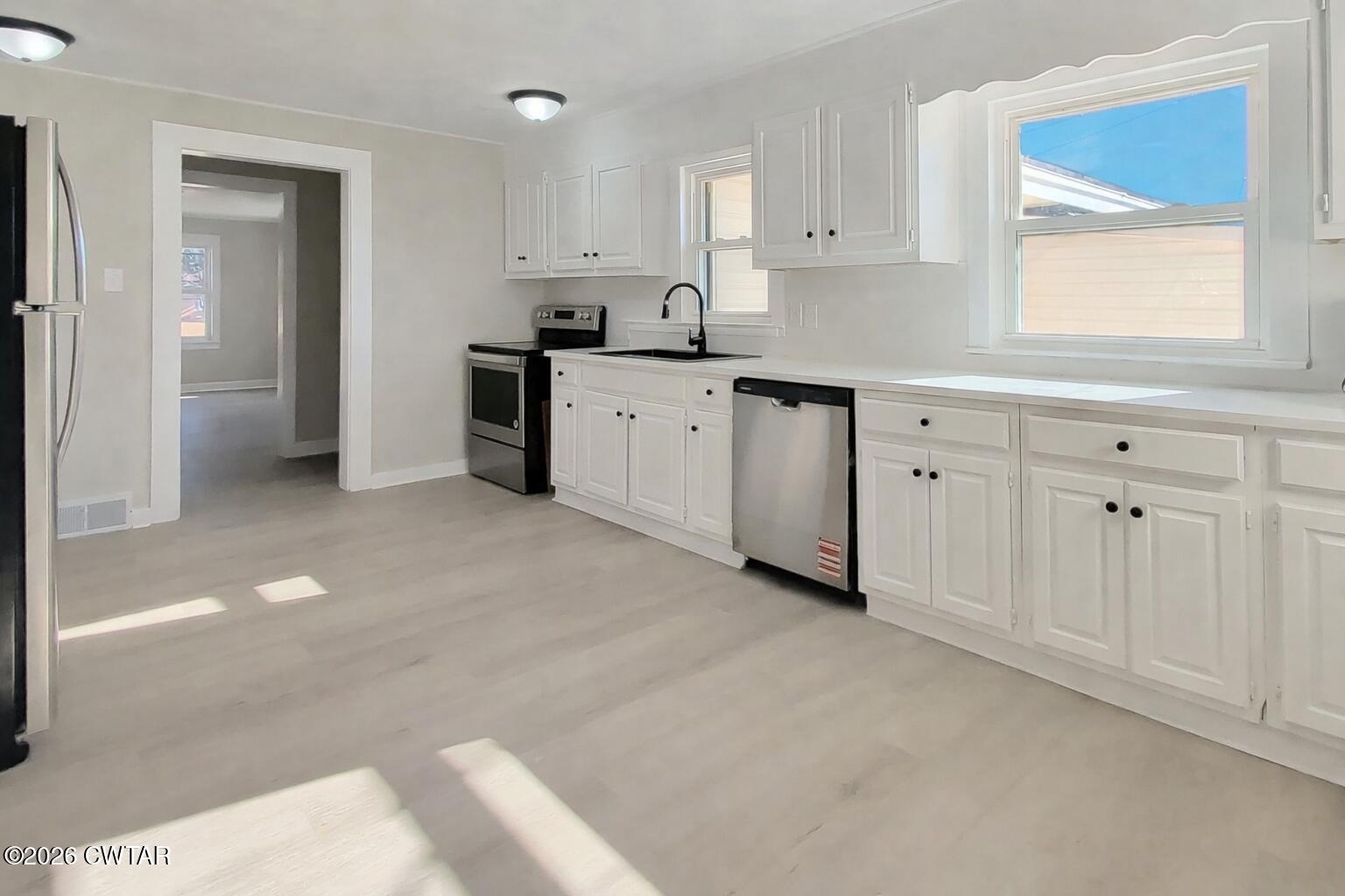 967 Broad Street North Lexington, TN 38351 - Photo 8 of 12 a kitchen with granite countertop white cabinets white stainless steel appliances with a sink and windows