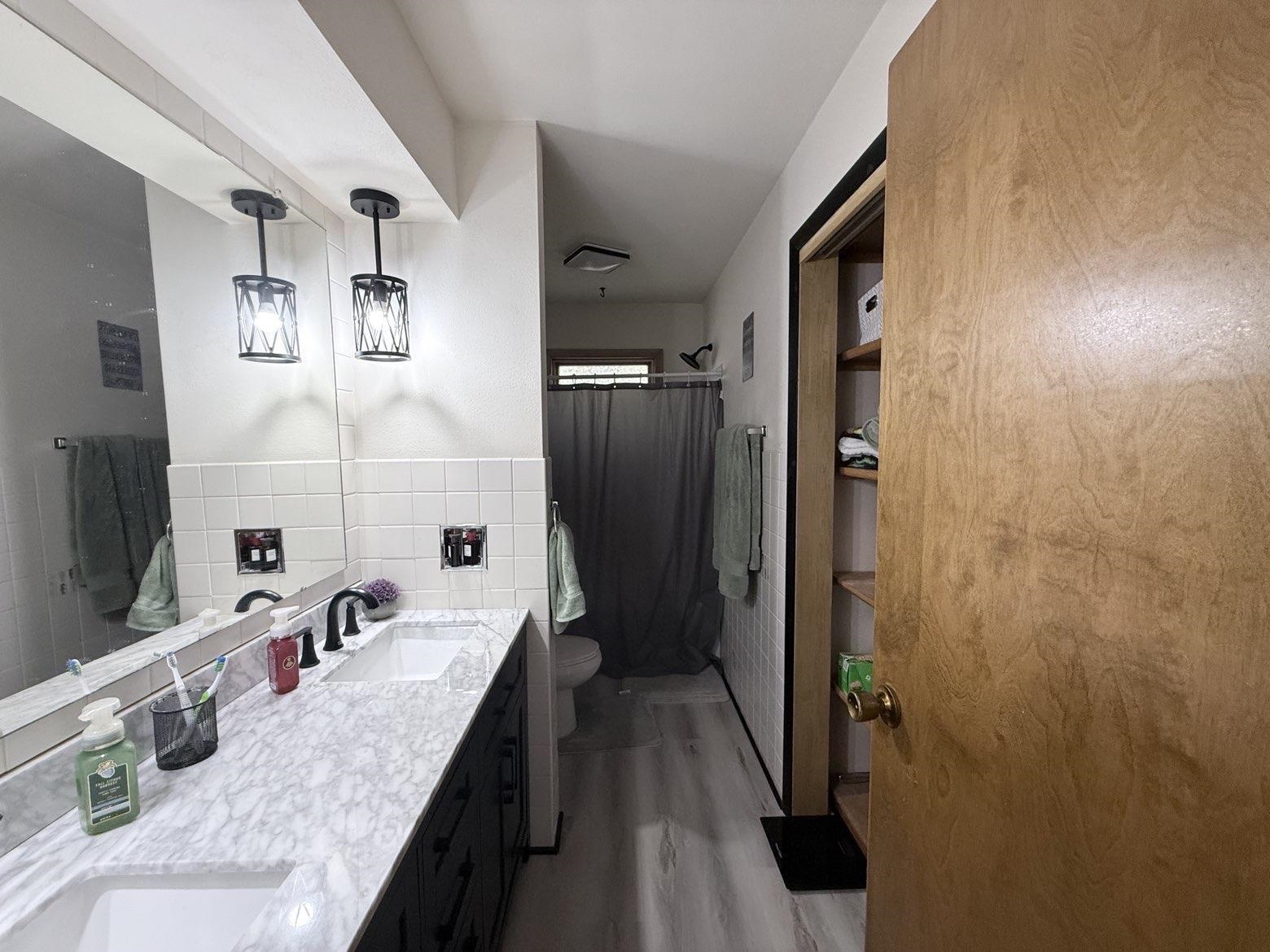 214 South Long Street Warren, IL 61087 - Photo 8 of 28 a bathroom with a granite countertop sink a mirror and shower