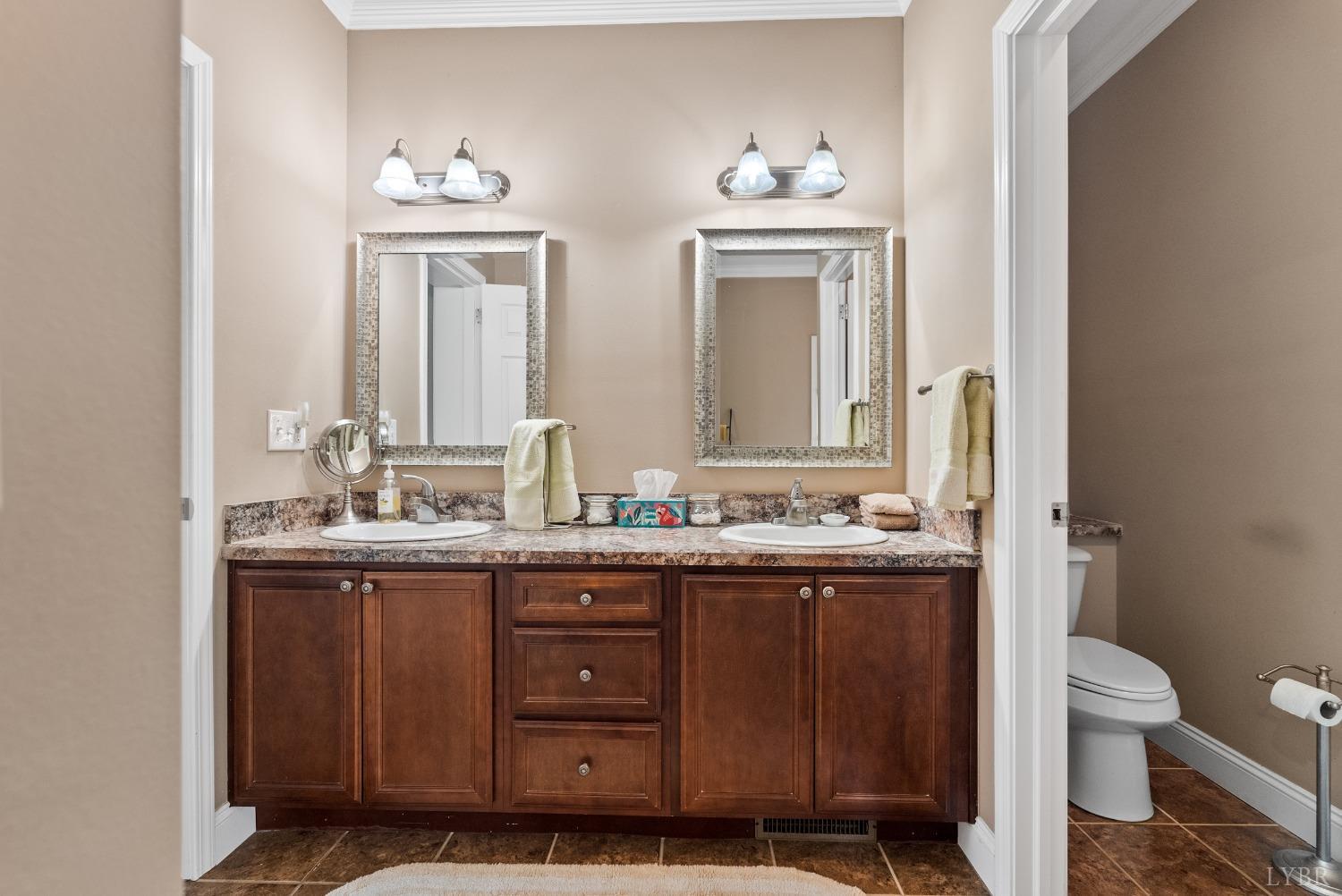 615 Spring Street Hurt, VA 24563 - Photo 23 of 63 a bathroom with a granite countertop toilet a sink and a mirror