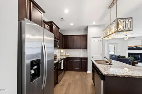 a kitchen with stainless steel appliances granite countertop a stove microwave refrigerator and sink