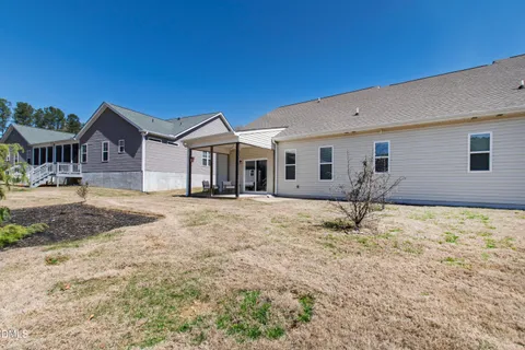 a view of a patio with a table chairs and a floor to ceiling window