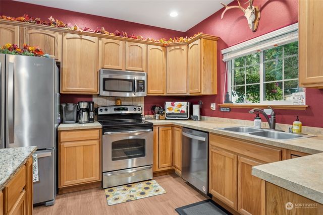a kitchen with stainless steel appliances a stove sink and microwave