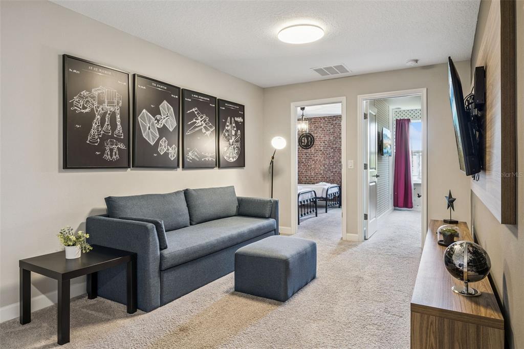8008 Formosa Valley Place Kissimmee, FL 34747 - Photo 12 of 55 a living room with furniture a couch and a flat screen tv
