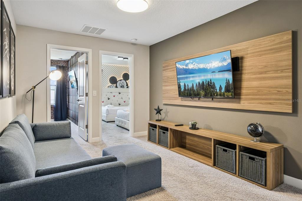 8008 Formosa Valley Place Kissimmee, FL 34747 - Photo 13 of 55 a living room with stainless steel appliances kitchen island granite countertop furniture and a flat screen tv